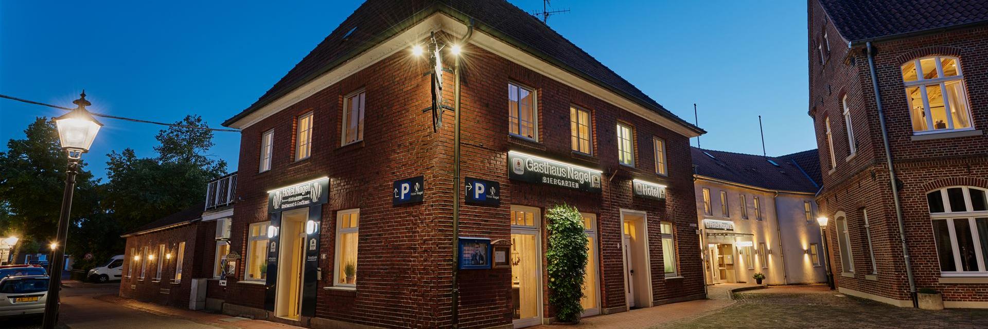 Außenansicht vom Hotel am Abend von der Kirche aus gesehen.