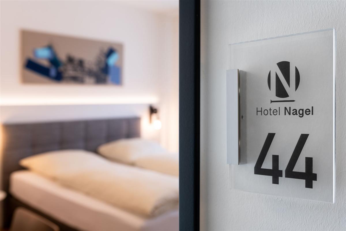 Nahaufnahme einer Zimmernummer mit im Hintergrund das Zimmer (unscharf)